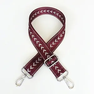 Macro detail of adjustable purple nylon shoulder strap with silver metal hooks and arrow pattern