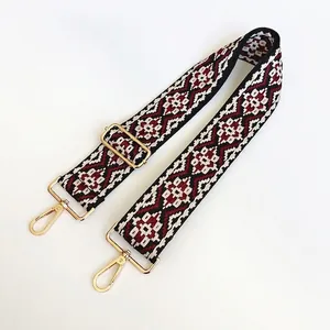 Close-up of ethnic geometric weave bag strap with golden swivel hooks and adjustable buckle