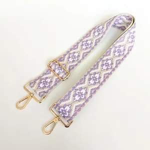 Close-up of geometric purple and white jacquard canvas strap with golden metal buckle