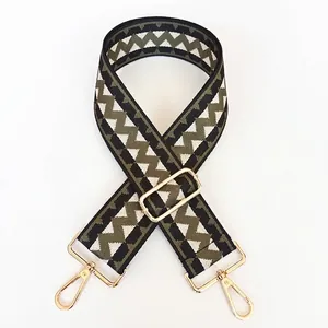 Close-up of style 19 woven wide strap with green geometric patterns and gold metal hooks