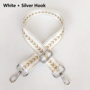 Detail of white nylon bag strap with gold V-pattern weaving and silver lobster clasps