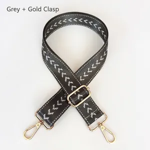 Grey adjustable nylon shoulder strap with white chevron patterns and gold swivel hooks