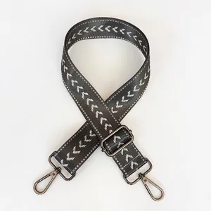 Detail of gray nylon shoulder strap with white chevron pattern and gunmetal hooks
