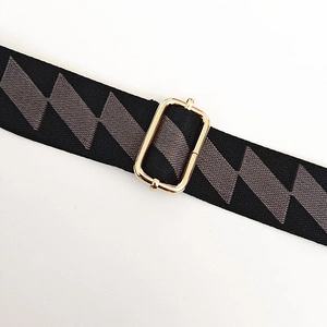 Close-up of adjustable strap with geometric pattern and golden metal buckle