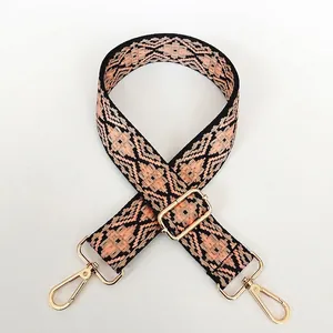 Detail of bohemian geometric woven bag strap with golden metal lobster clasps
