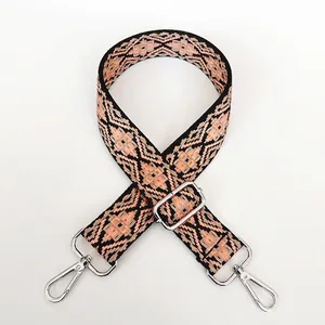 Detail of adjustable orange and black geometric pattern canvas shoulder strap with silver clasps