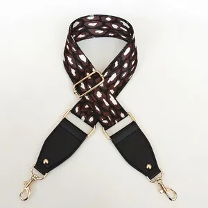 Detail showing the adjustable leopard print nylon shoulder strap with gold swivel lobster hooks