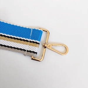 Detail of the 5cm wide striped bag strap with gold lobster clasp and reinforced stitching