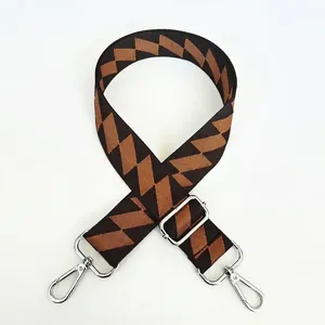 Detail view of coffee-colored checkered bag strap with silver metal swivel hooks