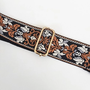 Detail showing jacquard floral pattern on bag strap with gold adjustable metal buckle