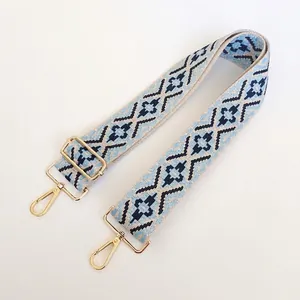 Close-up of geometric woven nylon strap with gold metal buckles and spring clasps