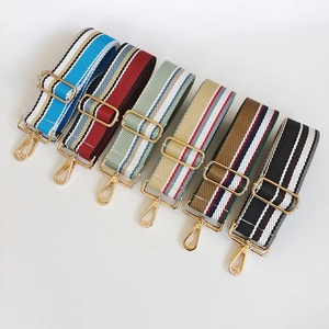 Detail of adjustable wide canvas shoulder straps with colorful stripes and gold metal hardware