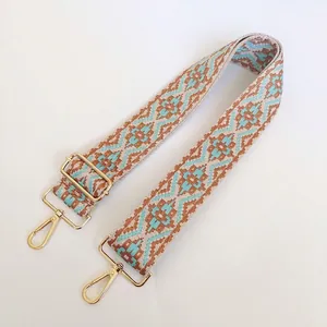 Detail of wide ethnic geometric guitar strap with golden metal hooks for handbags