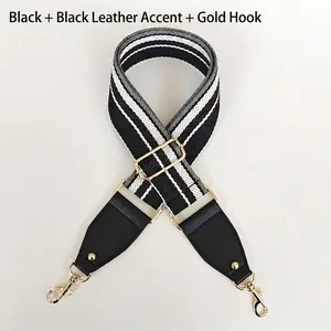 Detail view of adjustable wide canvas bag strap with black and white stripes and gold hooks