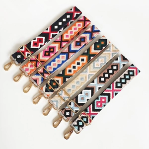 Detail of adjustable wide shoulder straps with ethnic geometric patterns and gold metal clips