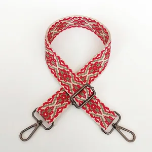 Detailed view of woven jacquard bag strap with geometric patterns and gunmetal lobster hooks