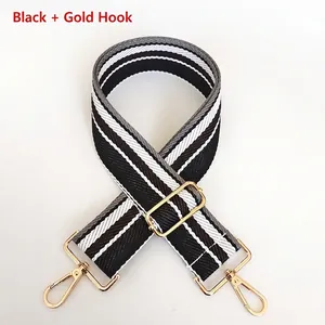 Detail of adjustable black and grey striped handbag strap with gold metal lobster clasp