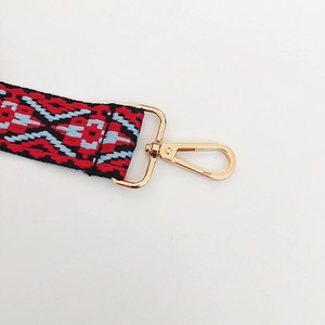 Detail of colorful jacquard canvas strap with geometric patterns and golden lobster clasp