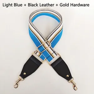 Detail of adjustable canvas bag strap with light blue stripes and gold swivel hooks