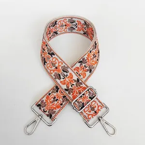 Close-up of ethnic style jacquard woven bag strap with silver metal hooks and adjusters