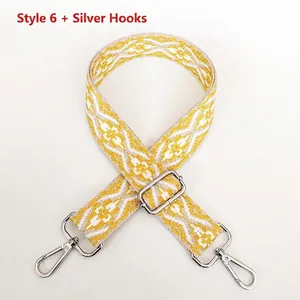 Close-up of ethnic geometric weave bag strap with silver lobster hooks and yellow pattern