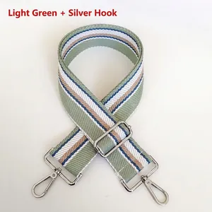 Detail of adjustable light green striped 5cm wide woven bag strap with silver hardware