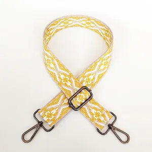 Close-up of jacquard wide purse strap with yellow geometric patterns and gunmetal lobster clasps