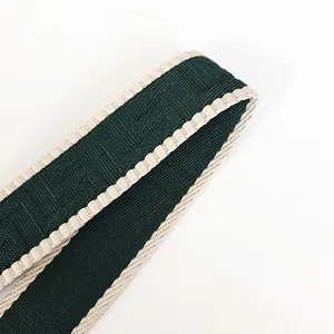 Dettaglio macro della tracolla regolabile in tessuto con motivo jacquard doppia F verde