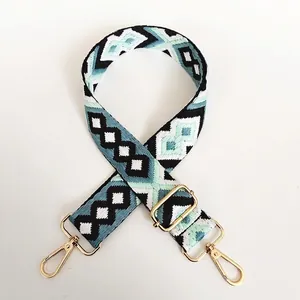 Detail of colorful geometric canvas bag strap with gold metal buckle and swivel hooks