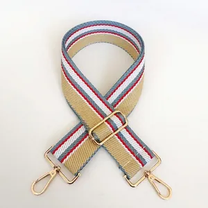 Detail of adjustable khaki woven shoulder strap with red stripes and gold hooks
