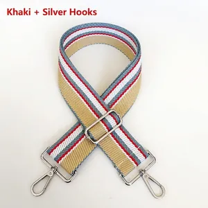 Detail of adjustable wide woven shoulder strap in khaki stripes with silver metal hooks
