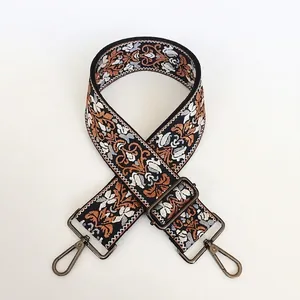 Close-up of vintage embroidery purse strap with gunmetal swivel hooks and floral patterns
