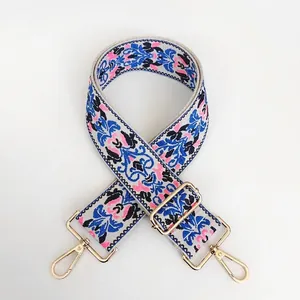 Detail of embroidered bohemian bag strap with geometric floral patterns and gold metal hooks