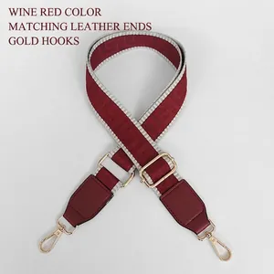 Dettaglio tracolla jacquard bordeaux con finiture dorate e inserti in pelle rossa