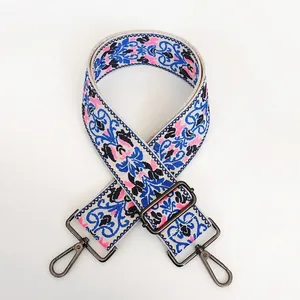 Detail of floral embroidery canvas bag strap with gunmetal swivel hooks and buckle