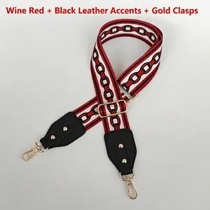 Detalle de correa étnica rojo vino con cuero negro y mosquetones metálicos dorados