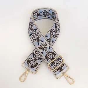 Detail view of retro blue jacquard embroidery bag strap with gold metal lobster clasps