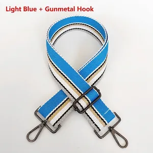 Close-up of light blue striped nylon bag strap with dark grey metal lobster clasps