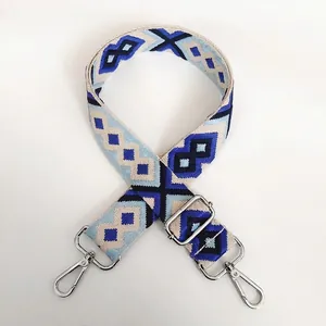 Detail of adjustable blue geometric diamond pattern canvas bag strap with silver metal hooks