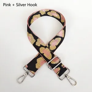 Close-up of pink leopard print bag strap with silver metal hooks and adjustable buckle
