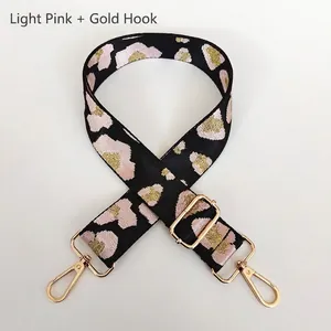 Detail of adjustable leopard print bag strap with golden metal lobster clasps