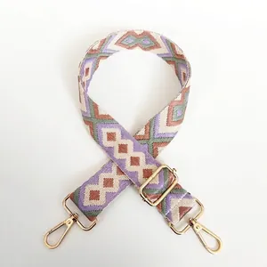 Detail view of thickened geometric diamond jacquard strap with gold-plated metal hardware