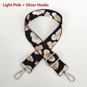 Close-up of pink and gold geometric patterned bag strap with silver swivel hook
