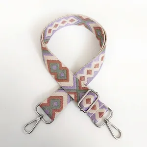 Detail of diamond pattern woven canvas shoulder strap with silver metal swivel hooks