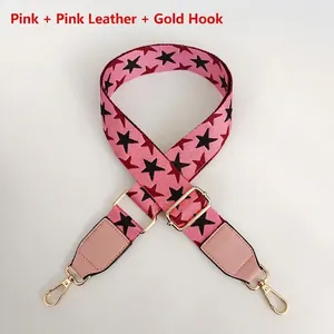 Detail of pink star patterned bag strap with golden metal hooks and leather trim