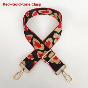 Detail of red and gold leopard jacquard bag strap with polished metal swivel hooks
