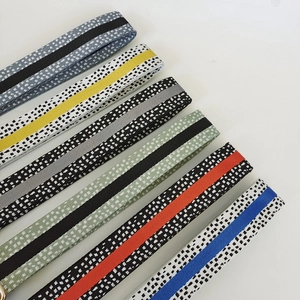 Detail showing diagonal array of striped woven straps with colorful patterns for bags