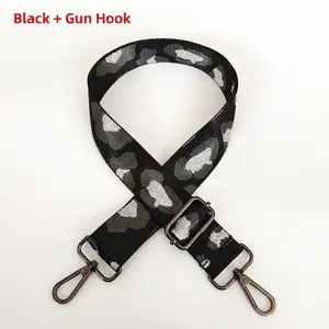 Close-up of adjustable leopard pattern bag strap with gunmetal swivel hooks and slider