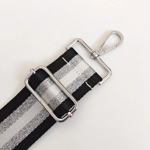 Close-up of striped woven strap with polished silver metal buckle and lobster clasp