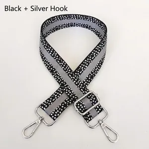 Detail of adjustable black and white jacquard wide shoulder strap with silver hooks
